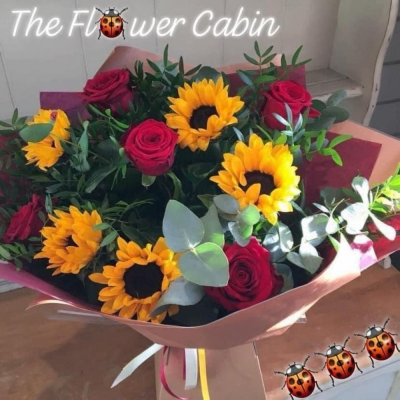 Sunflower Kisses - A hand tied bouquet of luxury roses and sunflowers paired fresh foliage. Complete in a water bubble and box.