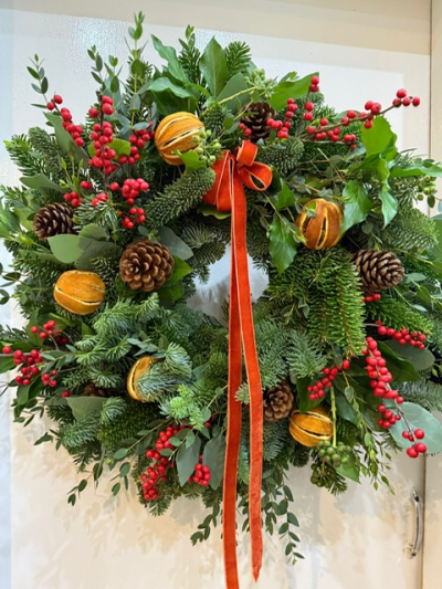 The Holiday Luxury Door Wreath - A luxurious spruce wreath with berried ivy and eucalyptus. Decorated with whole clementine's, fresh Ilex berries and pine cones - finished off with a burnt orange velvet ribbon. Handmade by us at The Flower Cabin.