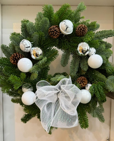 'The Snowman' Traditional Door Wreath - A traditional spruce wreath decorated with white and silver baubles, pine cones and white bells - finished off with a white mesh bow.