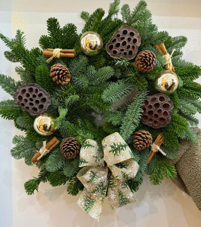 'It's A Wonderful Life - A traditional spruce wreath decorated with gold baubles, pine cones, lotus heads and twine wrapped cinnamon - finished off with a snowy tree bow.